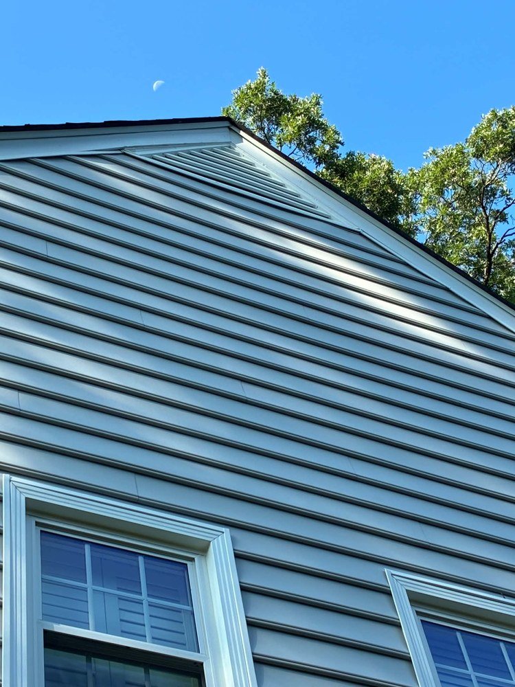 Newly repaired vinyl siding after completed work by Magothy Roofing and Exteriors
