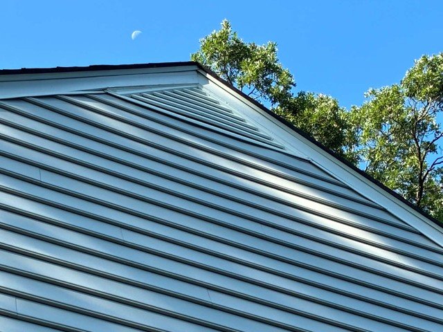 Close-up of repaired siding and trim along the roofline